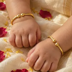 22K gold baby bangles on a baby's wrists